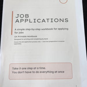 May include: A white paper workbook titled OPENPATH FUTURES JOB APPLICATIONS. It includes the text: A simple step-by-step workbook for applying for jobs, UK Printable Workbook, Designed for printing and completing by hand, and Take it one step at a time.