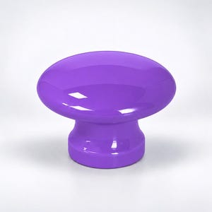May include: A solid purple cabinet knob with a smooth, glossy finish. The knob features a rounded, mushroom-shaped top that tapers down into a cylindrical base, providing a simple and functional design for furniture hardware applications.