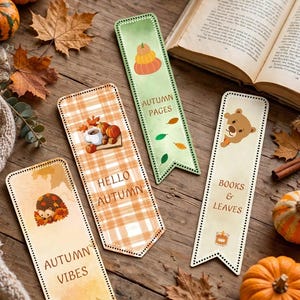 Può includere: Tre segnalibri rettangolari con angoli arrotondati e punte. Uno presenta un riccio e il testo AUTUMN VIBES, un altro un motivo a quadri con zucche e HELLO AUTUMN, e il terzo un orso con la scritta BOOKS & LEAVES.