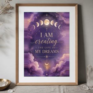 Könnte beinhalten: Ein gerahmter Wandkunstdruck mit einem violett-goldenen Himmelsdesign aus Wolken, Sternen und Mondphasen. Der Text I AM creating THE LIFE OF MY DREAMS steht in goldener Schrift in der Mitte eines kreisförmigen geometrischen Musters.