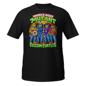May include: A black short-sleeve t-shirt featuring a graphic of four green turtles wearing bandanas and casual clothing. The text reads "MIDDLE-AGED MUTANT CUZZIN-TURTLES" in green and red letters. The turtles are depicted with various accessories.