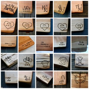 May include: A collection of 20 wooden cutting boards with various designs and text burned into the surface. The designs include hearts, bicycles, initials, and dates. The text includes names, dates, and phrases like "Kitchen" and "Family".