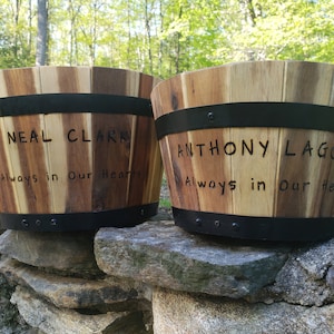 May include: Two wooden planter boxes with black metal bands. The boxes are engraved with the names "Neal Clark" and "Anthony Lagona" and the phrase "Always in Our Hearts".