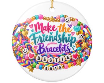 May include: A round white ceramic ornament featuring a colorful illustration of stacked friendship bracelets with beads, hearts, stars, and smiley faces. The text reads Make the Friendship Bracelets BESTIE ERAS in pink, teal, and purple script.