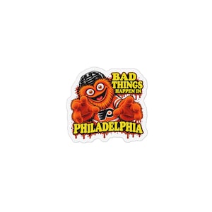 Op de afbeelding: Een gestanste sticker met een pluizig oranje wezen dat een zwarte ijshockeyhelm en een oranje-wit shirt draagt. De tekst BAD THINGS HAPPEN IN PHILADELPHIA staat in gele blokletters met een druipend rood verfeffect op de achtergrond.