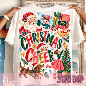 Puede incluir: Una camiseta blanca con un estampado gráfico colorido y el texto "CHRISTMAS CHEER". El diseño incluye un Santa Claus guiñando un ojo, un muñeco de nieve, un tocadiscos, un árbol de Navidad decorado, una persona con falda y un perro salchicha.