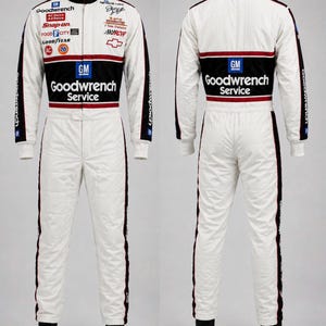 May include: A white racing suit with black and red accents, featuring Goodwrench Service branding, GM logos, and various sponsor patches on the front and back. The suit includes a high collar, long sleeves, and full-length legs with black trim.