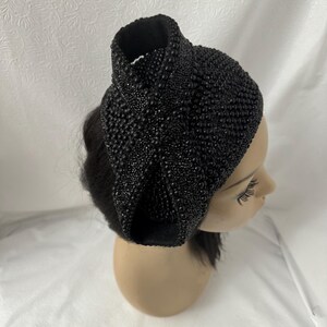 May include: A black beaded headband with a large bow on top. The headband is made of small, round beads that are sewn together.