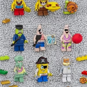 May include: A collection of nine plastic building block figures featuring characters from SpongeBob SquarePants, including SpongeBob, Patrick, Squidward, and Sandy, along with small accessories like a burger, a map, and gold bars.