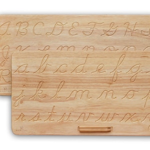 May include: Two rectangular light-colored wooden boards featuring engraved cursive letters. The front board displays the lowercase alphabet from a to z, while the back board shows uppercase letters. A small wooden stylus is attached to the front board.