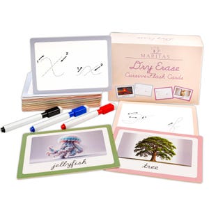 May include: A set of Maritas Dry Erase Cursive Flash Cards with a storage box, three markers in black, blue, and red, and multiple cards featuring dotted cursive letters with directional arrows, plus images of a jellyfish and a tree.