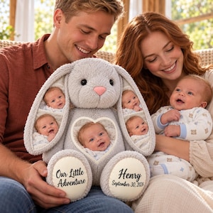 Könnte beinhalten: Ein graues Plüschhasen-Spielzeug mit fünf Fotoeinsätzen eines Babys an den Ohren und auf der Brust. Der Hase hat eine rosa Nase und cremefarbene Fußpolster mit dem aufgedruckten Text Our Little Adventure und Henry September 30, 2026.
