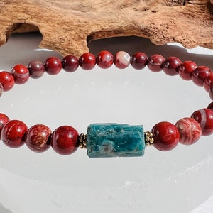 Puede incluir: Un brazalete de jaspe rojo con una cuenta de apatita azul. El brazalete est&aacute; hecho de cuentas de 8 mm y tiene una cuenta espaciadora dorada entre cada cuenta.