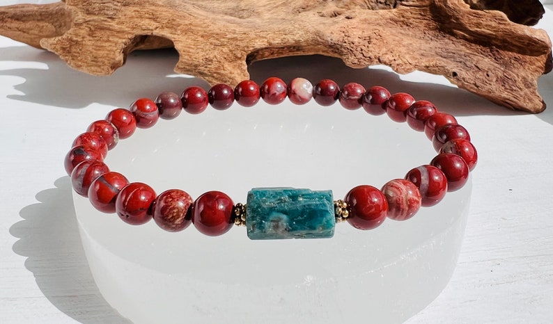 Puede incluir: Un brazalete de jaspe rojo con una cuenta de apatita azul. El brazalete est&aacute; hecho de cuentas de 8 mm y tiene una cuenta espaciadora dorada entre cada cuenta.