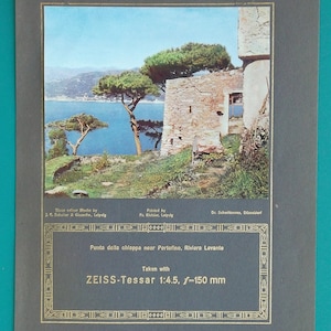 Könnte beinhalten: Vintage-Fotografie einer Küstenlandschaft mit einem Steingebäude und Pinien. Das Bild vor dem Hintergrund eines blauen Meeres und Himmels. Der Text unten lautet "Punta della chiappa near Portofino, Riviera Levante."