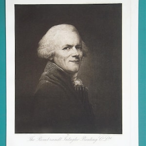 May include: A black and white portrait print of a person with short, light-colored hair, wearing a dark coat with a high collar. The print features the text "The Rembrandt Intaglio Printing Co Ltd" at the bottom and is set on a white rectangular paper.