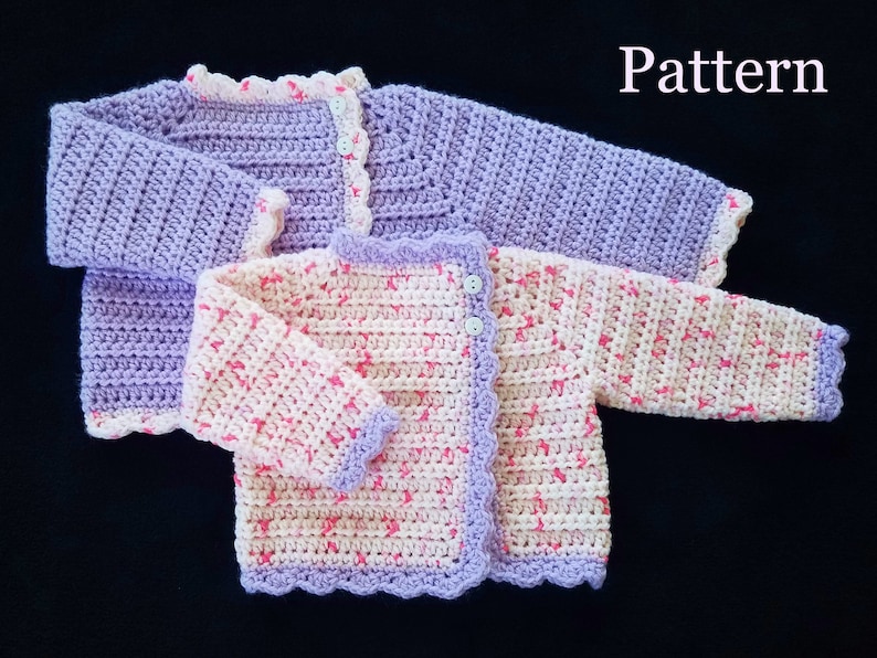 May include: Two crocheted baby sweaters, one in a light purple color and the other in a pink and white pattern. Both sweaters have a scalloped edge and button closures.