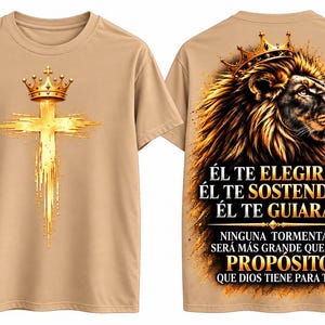 May include: A tan t-shirt featuring a gold crown atop a gold cross on the front. The back displays a lion wearing a crown with the Spanish text: "ÉL TE ELEGIRÁ, ÉL TE SOSTENDRÁ, ÉL TE GUIARÁ. NINGUNA TORMENTA SERÁ MÁS GRANDE QUE EL PROPÓSITO QUE DIOS TIENE PARA TI."