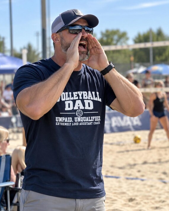 Dad wearing Volleyball Dad Assistant Coach tee cheering courtside