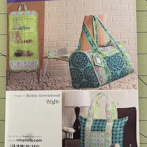 May include: A Simplicity 2600 sewing pattern envelope featuring designs by Robin Greenwood. The cover displays a hanging organizer, a duffel bag, a tote bag, and a small cylindrical case, all decorated with floral and leaf patterns in blue and green.
