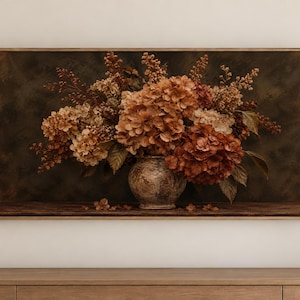 以下が含まれることがあります： 錆色、銅色、茶色のドライアジサイの花を、質感のある風化した陶器の花瓶に生けた、暗く雰囲気のある静物画を特徴とする長方形の額入りウォールアートプリント。暗い木製の表面に置かれています。
