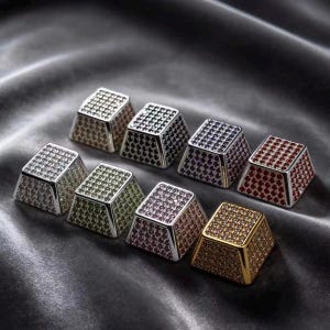 May include: Eight square-shaped mechanical keyboard keycaps arranged in two rows. Each keycap features a metallic base and is covered in small, sparkling rhinestones in various colors including silver, black, purple, red, green, pink, and gold.