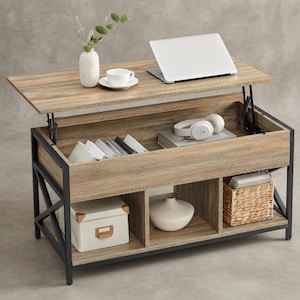 May include: A rectangular lift-top coffee table with a light wood grain finish and a black metal frame. The top is raised, revealing an interior storage compartment containing books and headphones. The base features three open shelves with a white box, a white vase, and a woven basket.