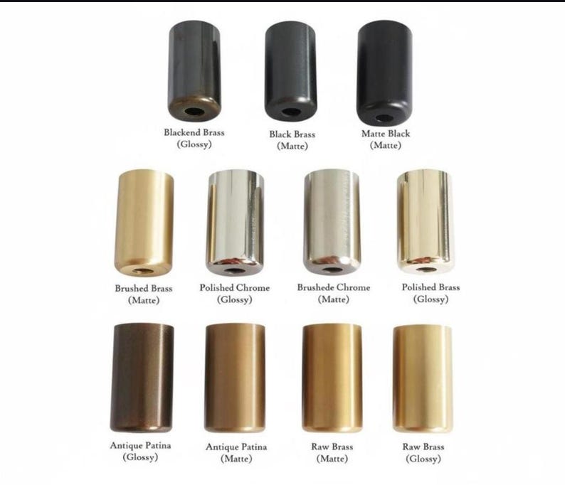 May include: A collection of eleven cylindrical metal hardware components arranged in three rows. Finishes include Blackened Brass, Black Brass, Matte Black, Brushed Brass, Polished Chrome, Brushed Chrome, Polished Brass, and Antique Patina.