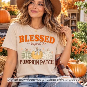 May include: A beige short-sleeve t-shirt featuring the orange text BLESSED beyond the PUMPKIN PATCH and an illustration of three pumpkins, one with a green plaid pattern, one with a polka dot bow, and one with a white heart pattern.