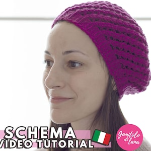 May include: A close-up of a woman wearing a bright pink crocheted beanie. The beanie has a textured stitch pattern. The text "SCHEMA E VIDEO TUTORIAL" is visible at the bottom of the image.