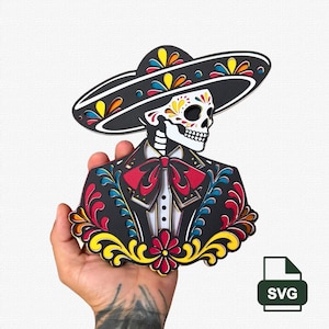 May include: A multi-layered laser-cut wooden wall art piece depicting a skeleton wearing a black sombrero and a formal suit with a red bow tie. The design features intricate floral patterns in yellow, red, and blue, with a white skull.