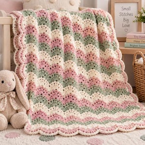 Può includere: Una coperta all'uncinetto con un motivo a onde smerlate in strisce alternate di color crema, rosa antico e verde salvia. Il tessuto presenta una lavorazione testurizzata ad anelli con una finitura decorativa a smerlo lungo il bordo.