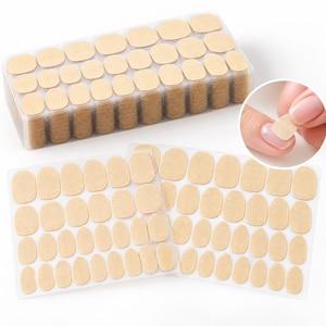 Peut inclure: Un grand récipient rectangulaire en plastique transparent rempli de piles de petites languettes adhésives ovales de couleur beige, accompagné de deux feuilles transparentes plates présentant des rangées de languettes adhésives beiges.