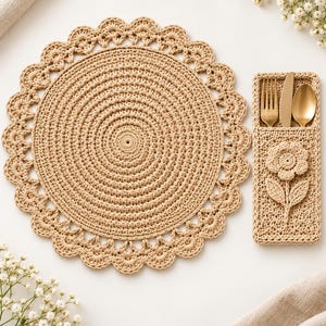 Può includere: Una tovaglietta rotonda all'uncinetto color beige con bordo smerlato e un portaposate rettangolare abbinato con un motivo floreale tridimensionale, contenente un set di forchetta, coltello e cucchiaio dorati.