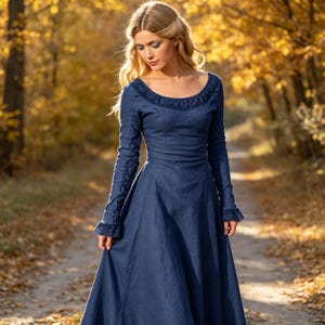 Può includere: Un abito blu navy a maniche lunghe con scollo rotondo e dettagli in pizzo. L'abito presenta un corpetto aderente che si trasforma in una gonna svasata, con inserti in pizzo coordinati sui polsini delle maniche e un tessuto testurizzato.