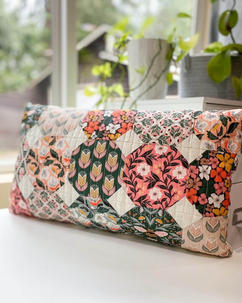 Honeycomb Pillow front view made with Honey Garden fabric, displayed on a white table in front of a window. Features a modern hexagon-inspired patchwork design.