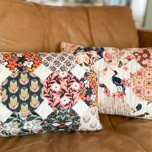 Two finished Honeycomb Pillows made with Honey Garden and Enchanted fabric collections by Cloud9 Fabrics, displayed on a brown leather couch. The quilted pillows feature a honeycomb-inspired patchwork design and are sewn in a 12" x 20" lumbar size.