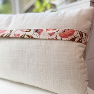 Back view of the Honeycomb Pillow showing the lapped zipper closure and floral accent fabric, displayed on a white table.