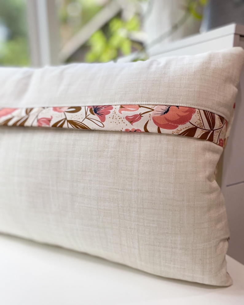 Back view of the Honeycomb Pillow showing the lapped zipper closure and floral accent fabric, displayed on a white table.