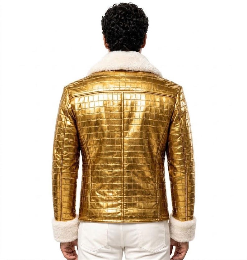 Puede incluir: Una chaqueta dorada metalizada con un patr&oacute;n texturizado de piel de cocodrilo, un cuello ancho de piel sint&eacute;tica blanca y pu&ntilde;os de piel sint&eacute;tica blanca a juego en las mangas largas. La chaqueta se lleva sobre pantalones blancos, vista de espaldas.