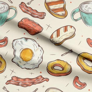 May include: A fabric pattern featuring a breakfast theme with illustrations of fried eggs, bacon strips, coffee mugs, pineapple rings, and small forks on a cream background. The design includes red dots and cross marks scattered across the surface.