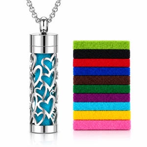 May include: A silver-toned cylindrical pendant necklace featuring a cut-out heart pattern with a bright blue felt insert. Beside the pendant is a stack of nine rectangular felt pads in various colors including green, black, red, blue, brown, purple, yellow, and pink.