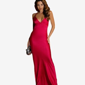 Vestido longo fúcsia de cetim, modelo slip com decote em V profundo, alças finas e costas abertas.