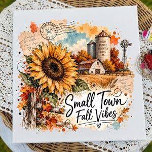 May include: A square canvas print featuring a large yellow sunflower, a rustic farm scene with a silo labeled 'GOOD PEOPLE BRIGHTER DAYS', a windmill, and autumn foliage. The text 'Small Town Fall Vibes' is written in black script.