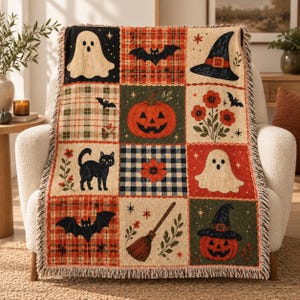 May include: A woven throw blanket featuring a grid of nine squares with Halloween motifs including a ghost, a bat, a witch hat, a jack-o'-lantern, a black cat, flowers, and a broomstick, all set against various plaid and solid backgrounds.
