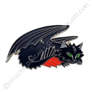 May include: A black cat pin with bat-like wings and red accents. The cat has bright green eyes and a silver outline. The pin is a stylized design with the text "BRADEN DUNCAN - CLOCKWORKART.COM" along the top edge.