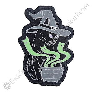 May include: Black cat wearing a witch's hat with a cauldron and green smoke coming out of it.