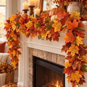 May include: A decorative autumn garland featuring a dense arrangement of artificial maple leaves in vibrant shades of red, orange, yellow, and green. The garland drapes over a white fireplace mantel, accented by two white candles and pumpkins.