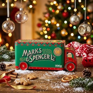 May include: A green and red metal tin shaped like a delivery truck, featuring the text Marks & Spencer Ltd and 200g. The truck design includes a gingerbread character in the driver's seat and decorative patterns on the roof and base edges.