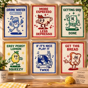 May include: Six framed crochet wall art pieces featuring cartoon characters and text. Designs include a glass of water, a coffee cup, a green character, a lemon, a record player, and a slice of bread with phrases like Drink Water and Get This Bread.